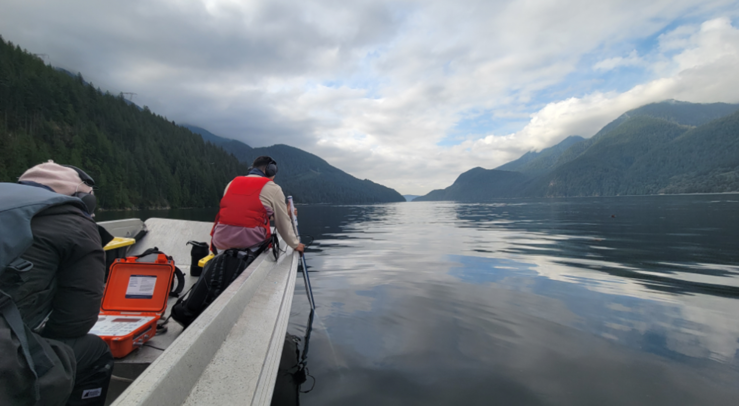 Scientist conduct water quality sampling from boat.